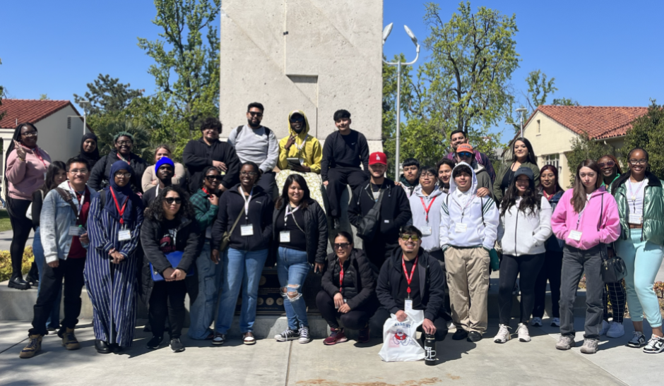 Student posing in front of a landmark at Fresno State University